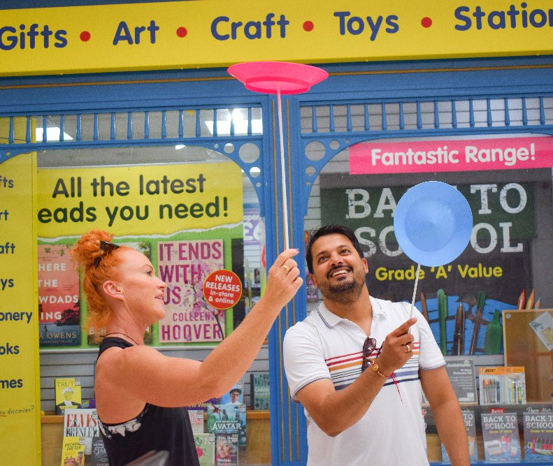 circus performer shows a member of the public how to spin a plate
